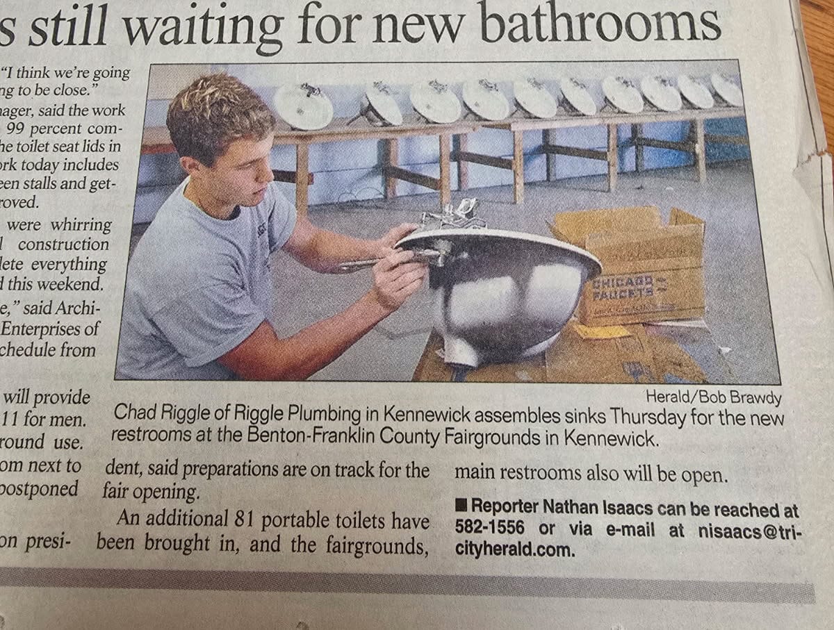 Plumber assembling sink for fairground restrooms