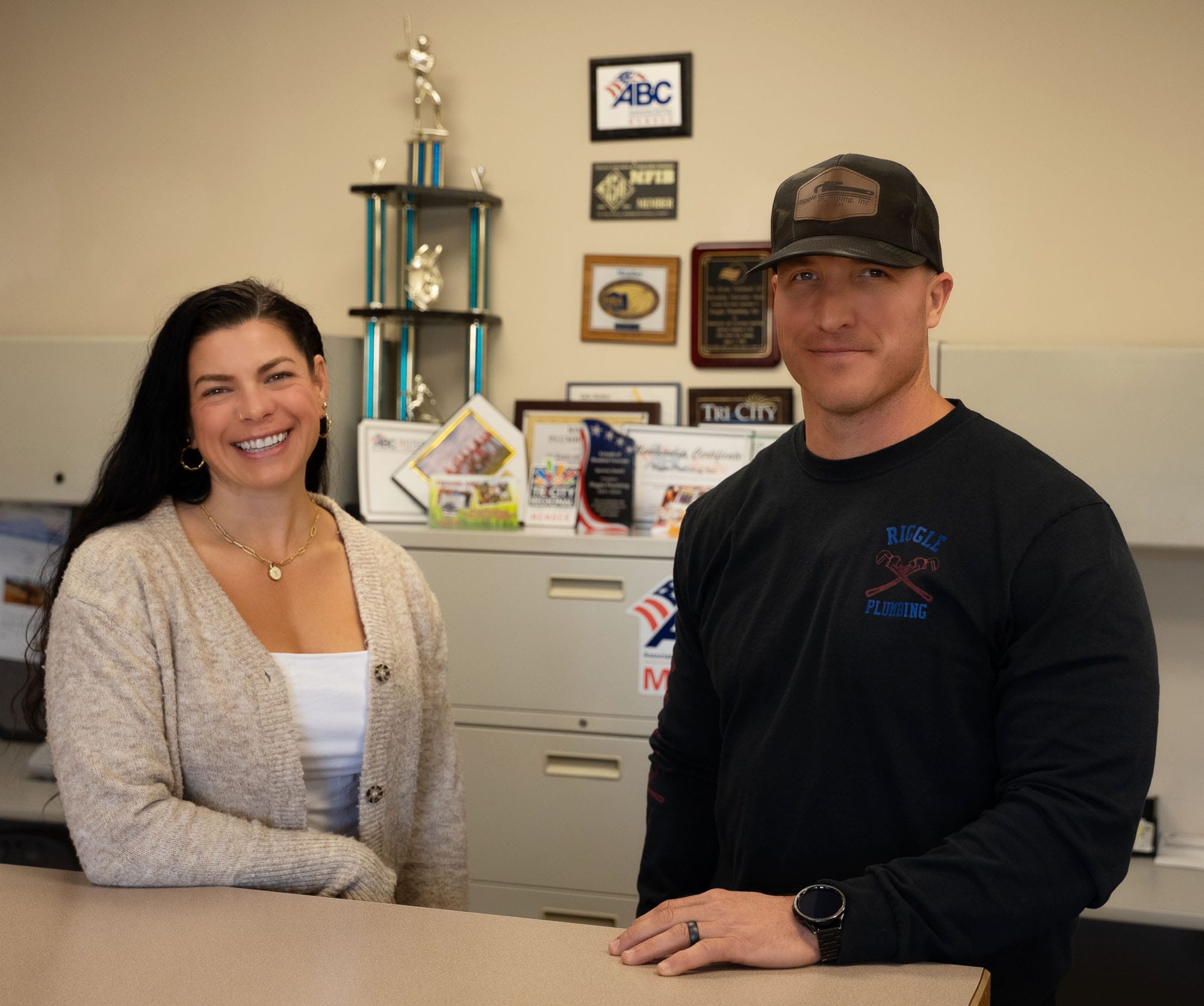 Two people smiling in an office setting.