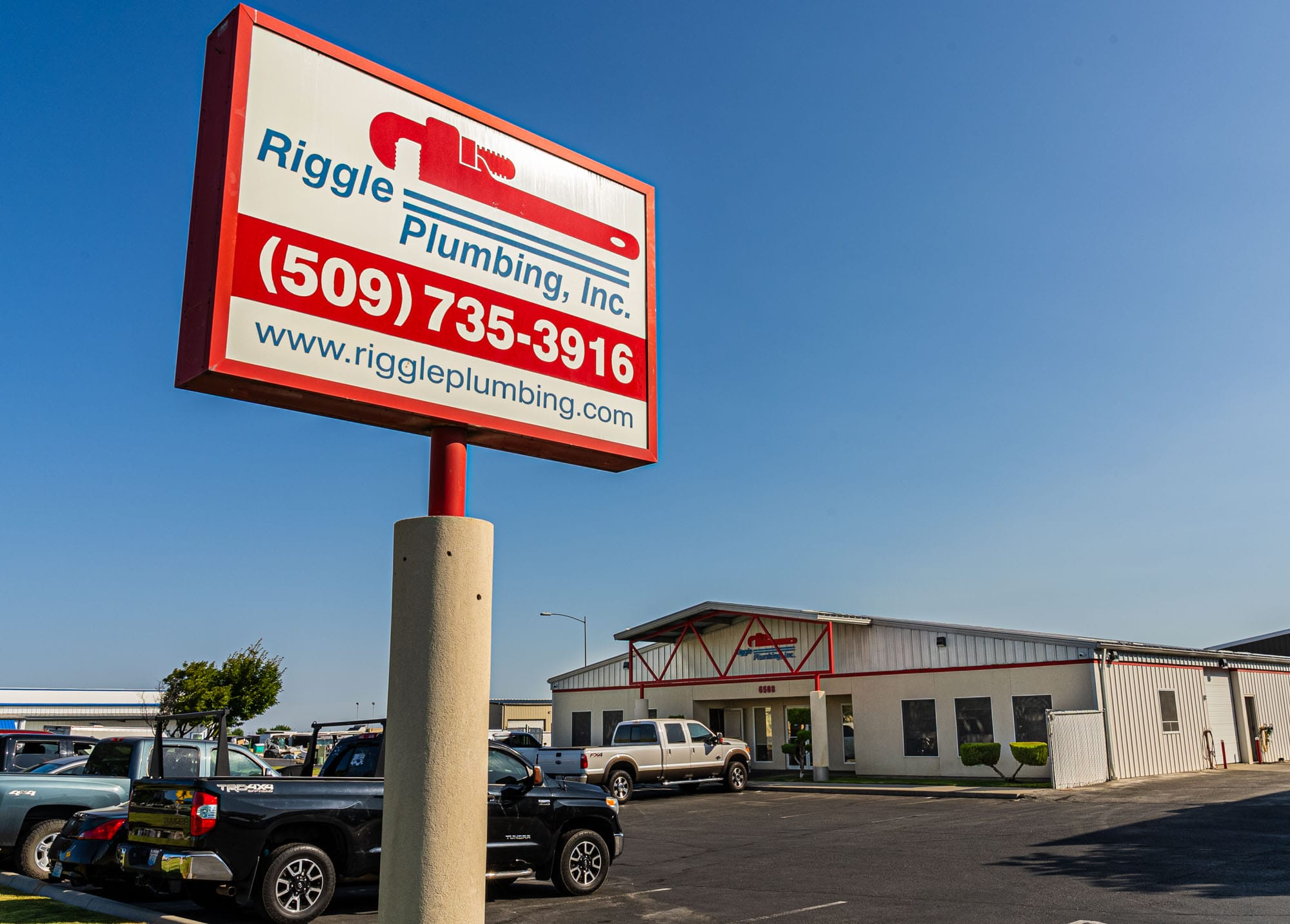 Riggle Plumbing office and sign with contact details.