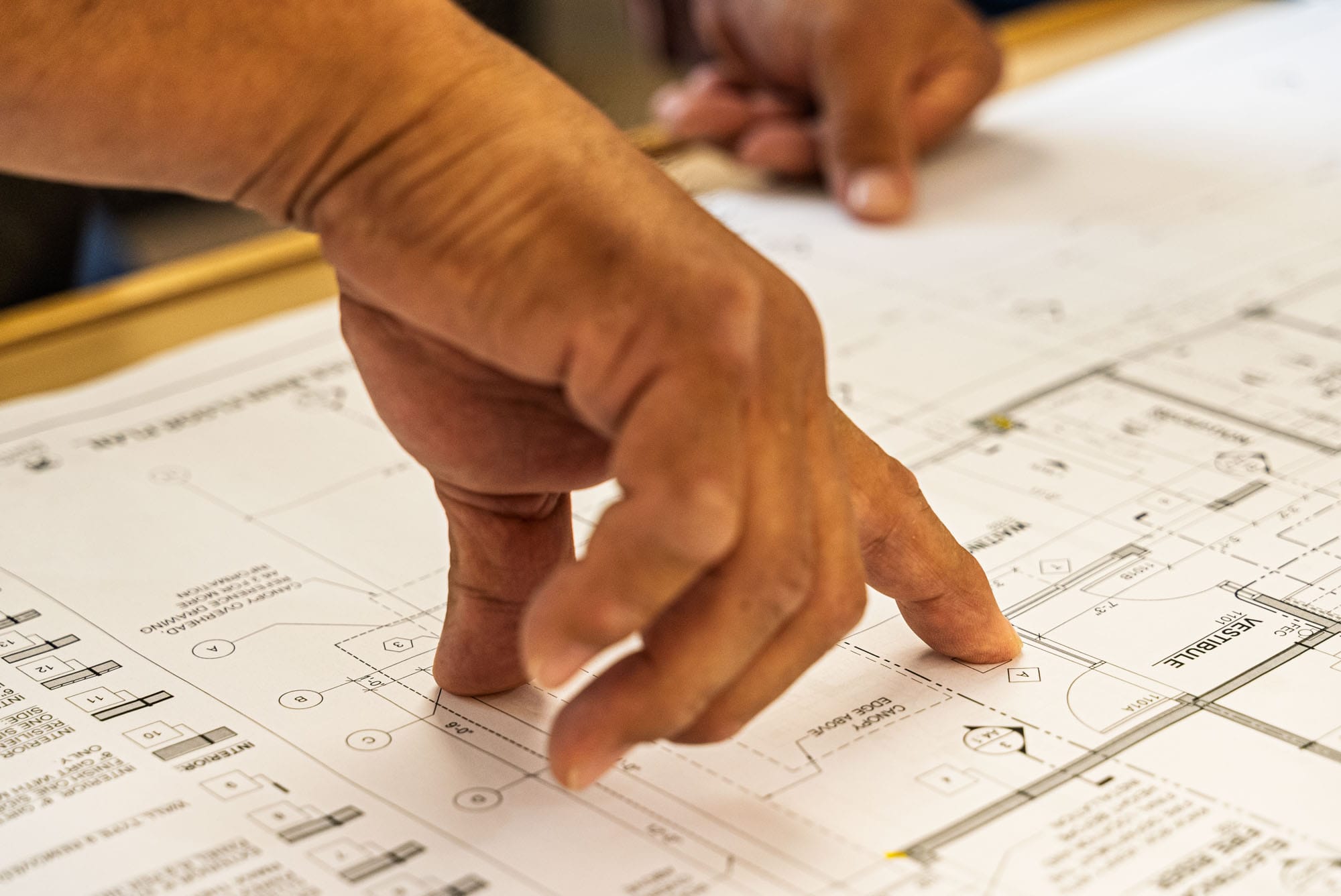 Riggle_Plumbing_0046 Hands pointing at architectural blueprint.