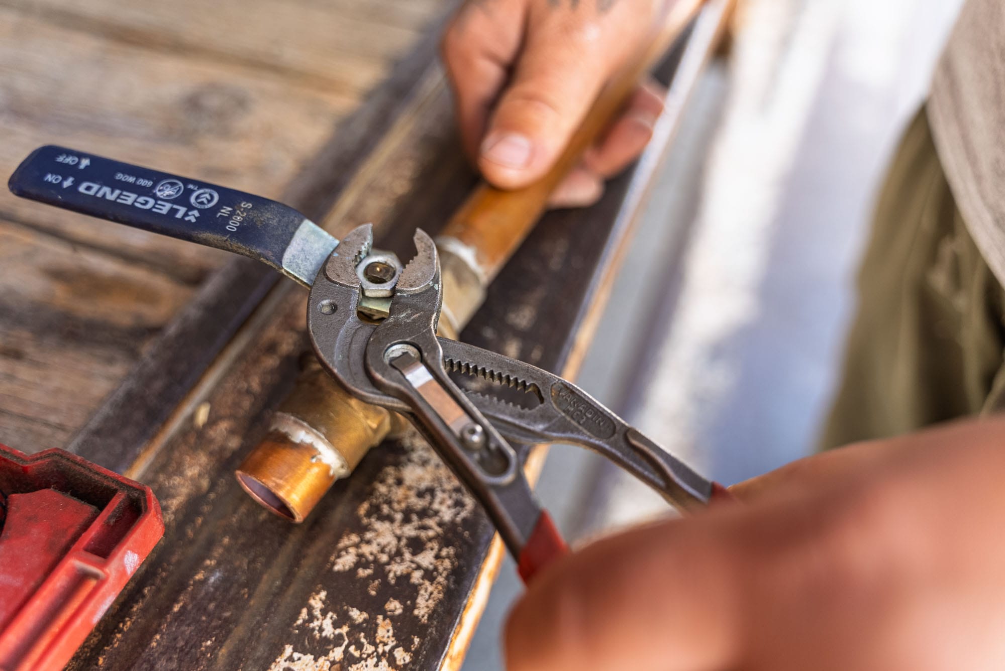 Plumber using wrench on copper pipe