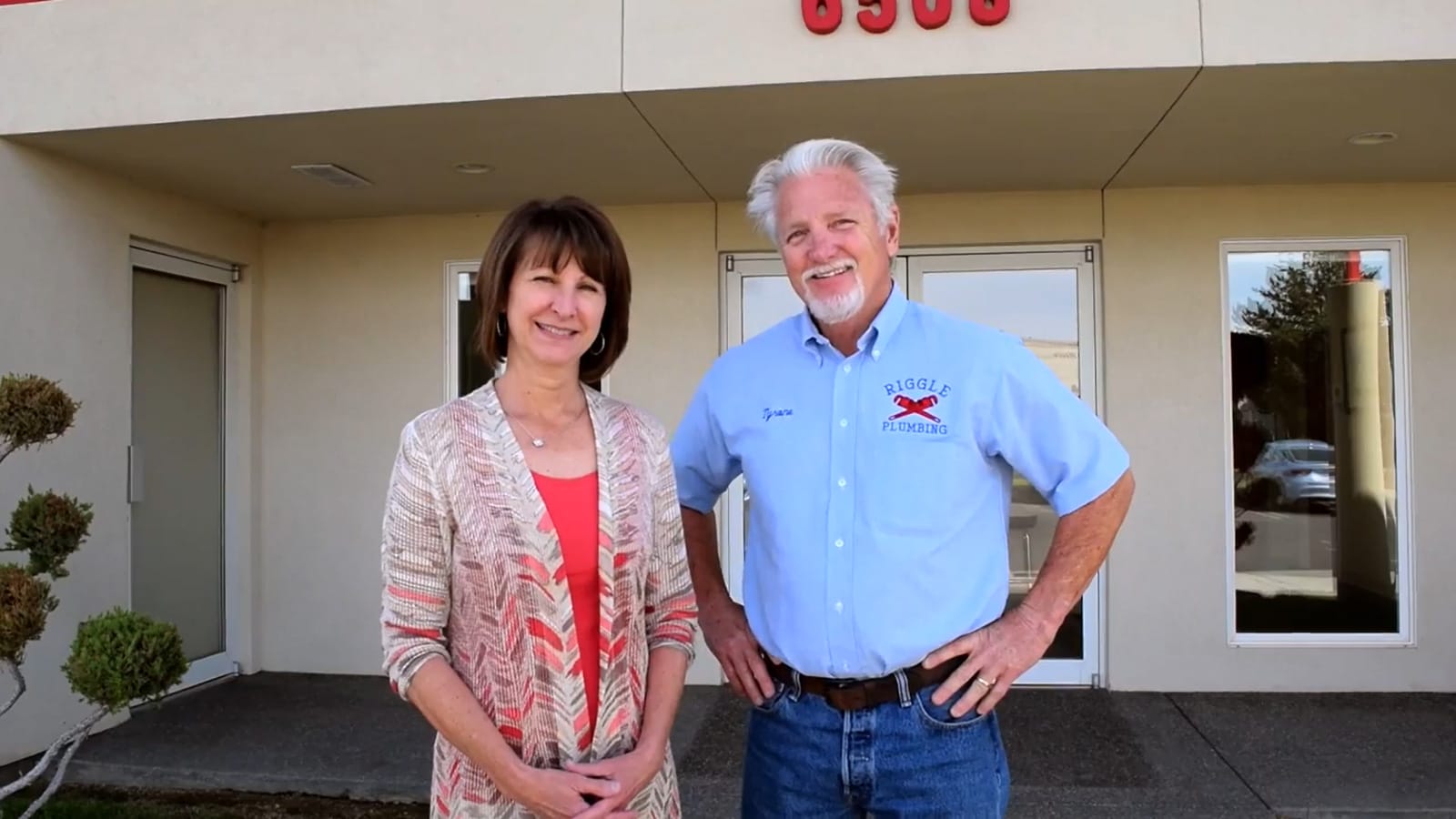 Tyrone & Cindy Riggle Smiling duo outside plumbing business entrance