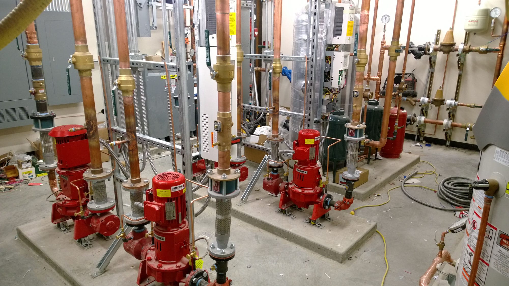 WP_20131206_15_01_26_Pro Mechanical room with red pumps and copper pipes.