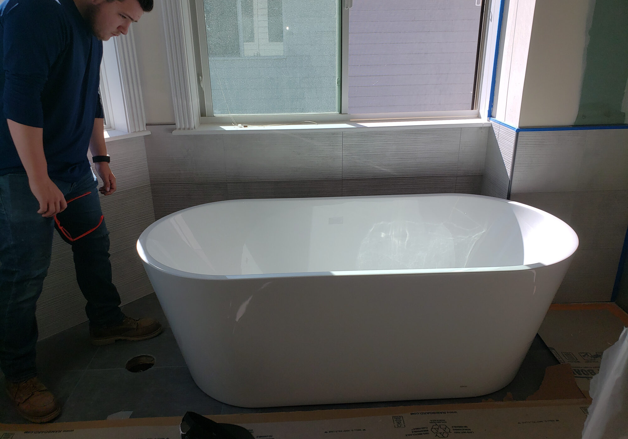 20210618_084416 Man inspecting modern bathtub installation