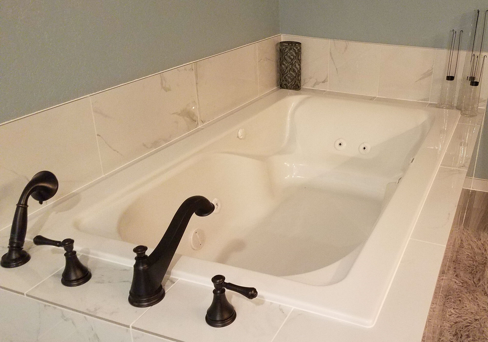 IMG_20191102_204040_457 Luxury bathtub with marble tile surrounds and black fixtures.